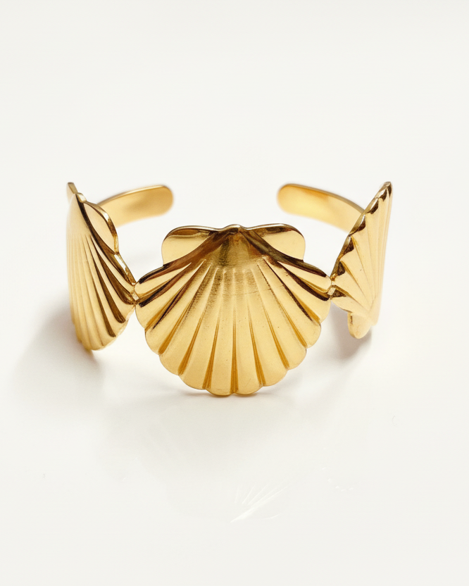 Gold seashell cuff bracelet on white background