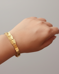 Gold scale texture bangle bracelet lifestyle shot worn on wrist