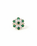 Gold emerald and diamond floral pinwheel cocktail ring on white background