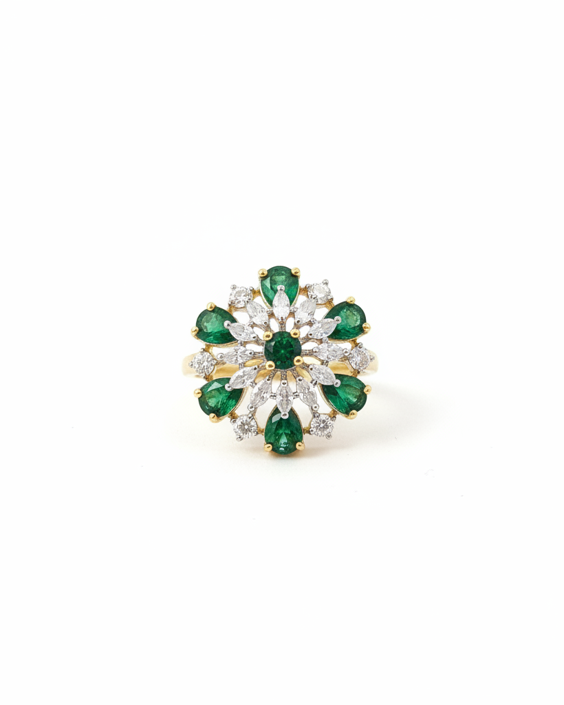 Gold emerald and diamond floral pinwheel cocktail ring on white background