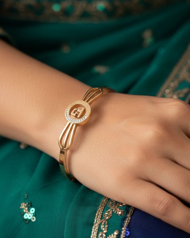 Gold medallion bow bangle lifestyle shot worn on wrist