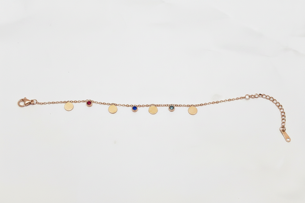 Rose gold disc and gemstone charm chain bracelet on white background