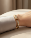 Model wearing gold hinged diamond bangle bracelet